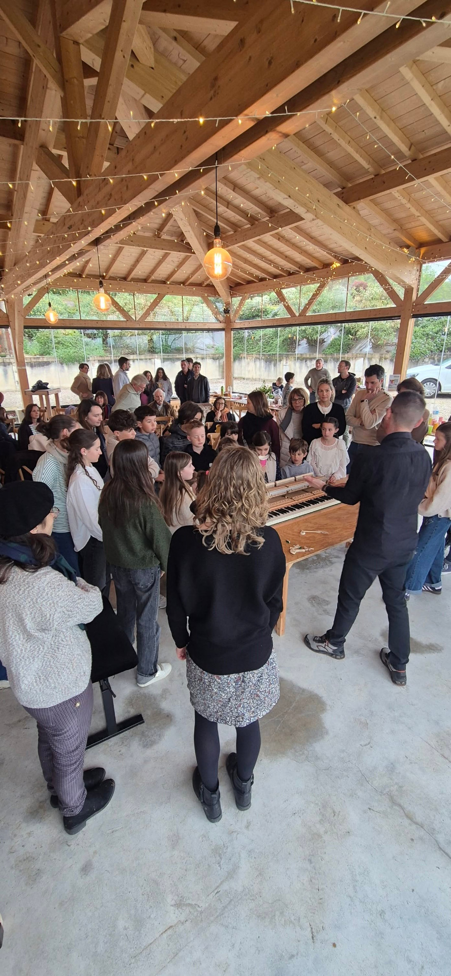 Démonstration d'une mécanique de piano à un groupe d'enfants et d'adultes