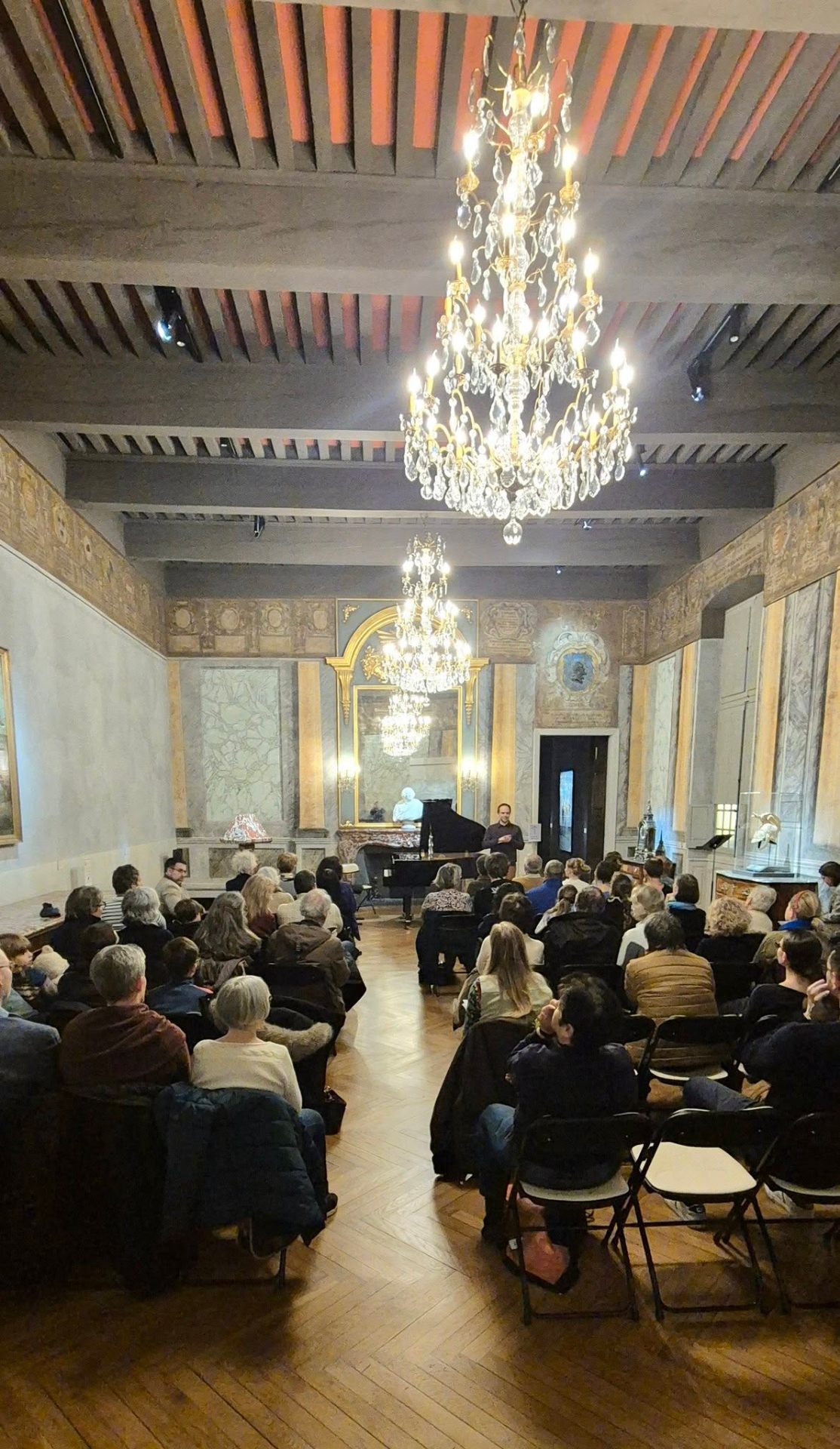 Concert de piano dans un grand salon avec lustres en cristal